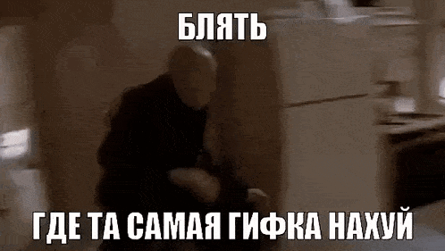 a man is sitting on the floor in front of a refrigerator in a room with russian writing on it .