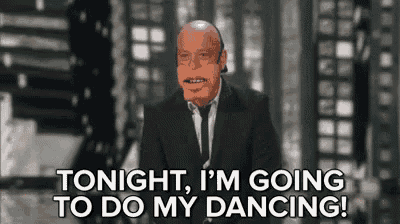 a bald man in a suit and tie is talking about dancing .