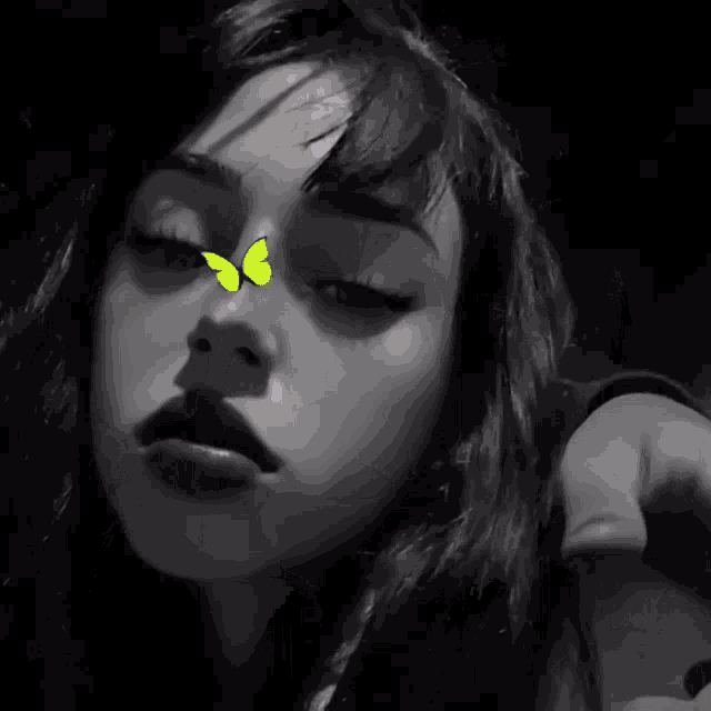 a woman with a yellow butterfly on her nose