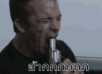 a man is holding a gun in his mouth .