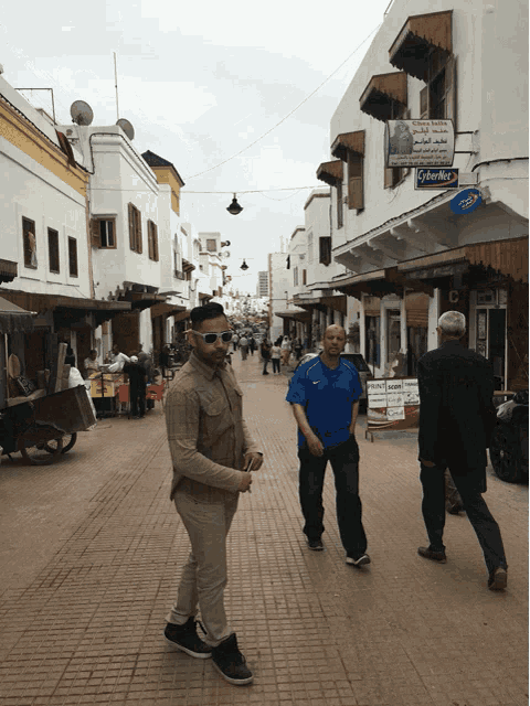 a man in a blue shirt walks down a busy street