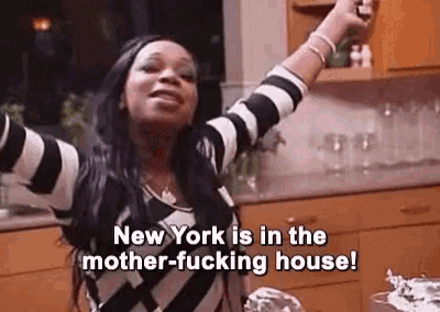 a woman is standing in a kitchen with her arms in the air and says `` new york is in the mother-fucking house '' .