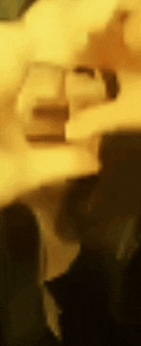 a blurry picture of a person in a dark room with a yellow background