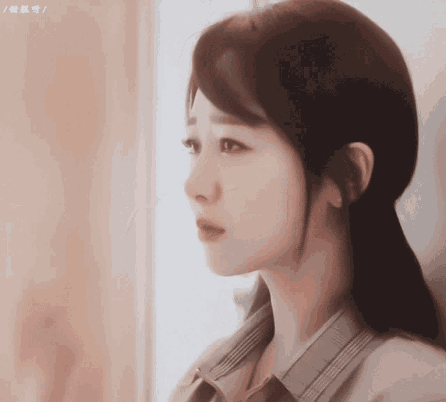 a close up of a woman 's face with chinese writing on the bottom right corner