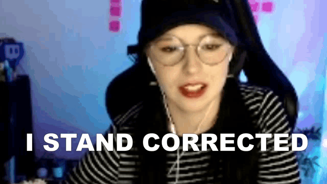 a woman wearing glasses and headphones is sitting in front of a computer screen with the words `` i stand corrected '' .