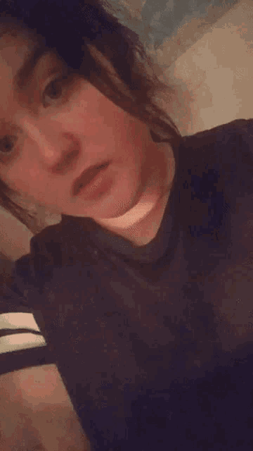 a woman is making a funny face with her eyes closed .
