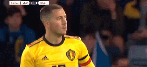 a soccer player wearing a yellow jersey with the number 17 on it is standing in front of a crowd .