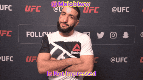 a man with his arms crossed is standing in front of a ufc banner