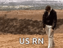 a man is walking on a sandy beach with the words us rn written on the ground .