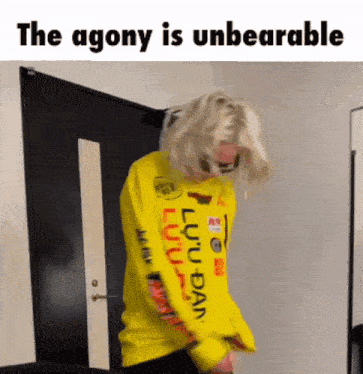 a person wearing a yellow sweatshirt with the words `` the agony is unbearable '' written on it .