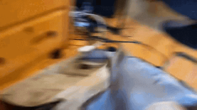 a blurred image of a dresser with a bunch of cords on it