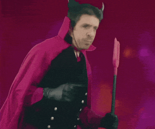 a man in a vampire costume holds a trident