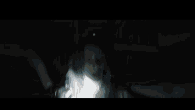 a blurry picture of a person with blue hair in a dark room