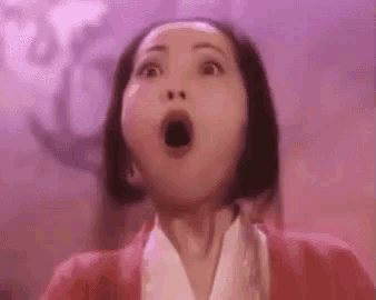 a woman is making a surprised face with her mouth open in front of a purple background .