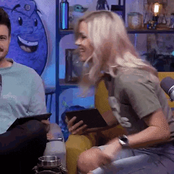 a man and a woman are sitting on a couch with a tablet .