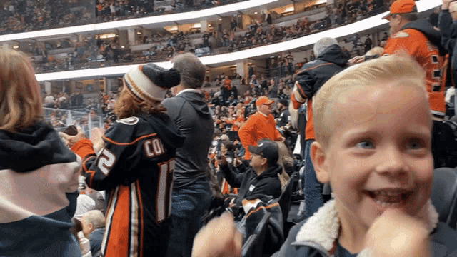 a boy wearing a jersey with the number 11 on it stands in a crowd