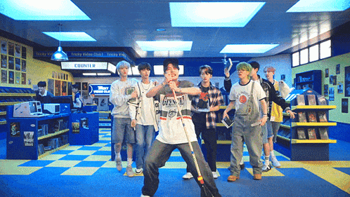 a group of young men are dancing in a store with a sign that says country