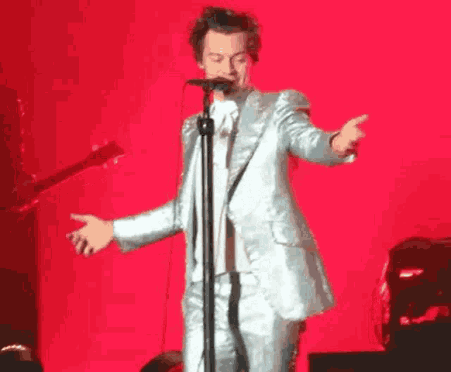 a man in a suit is standing on a stage in front of a microphone .