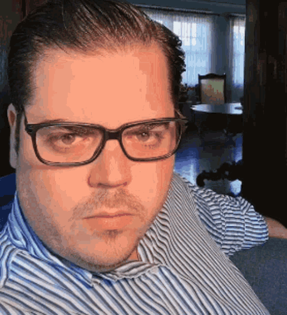a man wearing glasses and a blue and white striped shirt