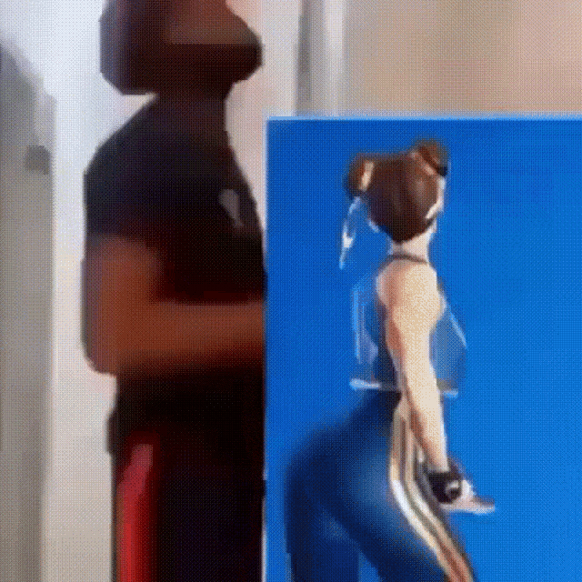a man is standing next to a picture of a woman in a video game costume .