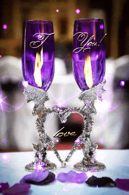 two purple wine glasses with candles in them and the words i love you