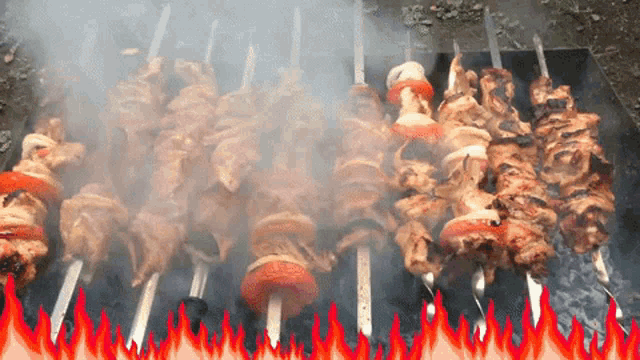 a bunch of skewers of meat are cooking on a grill
