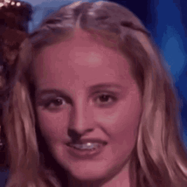 a close up of a woman 's face with braces on her teeth smiling .