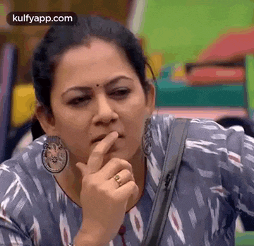 a woman is making a funny face with her finger to her mouth .