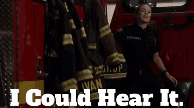 a woman in a fireman 's uniform stands in front of a fire truck with the words i could hear it below her