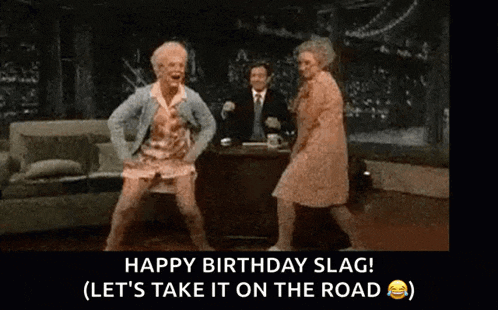 two older women are dancing in a living room with a man sitting at a desk .