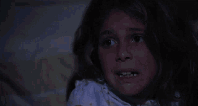 a young girl is screaming with her mouth open