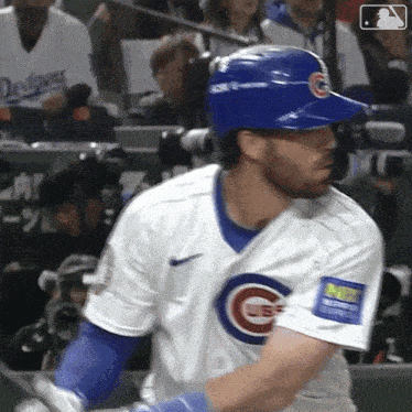 a baseball player in a cubs uniform is swinging his bat at a pitch .