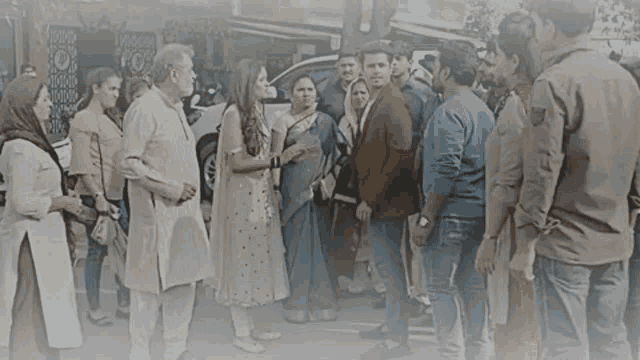 a group of people are standing in a line on the side of the road .