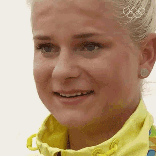 a close up of a woman wearing a yellow jacket