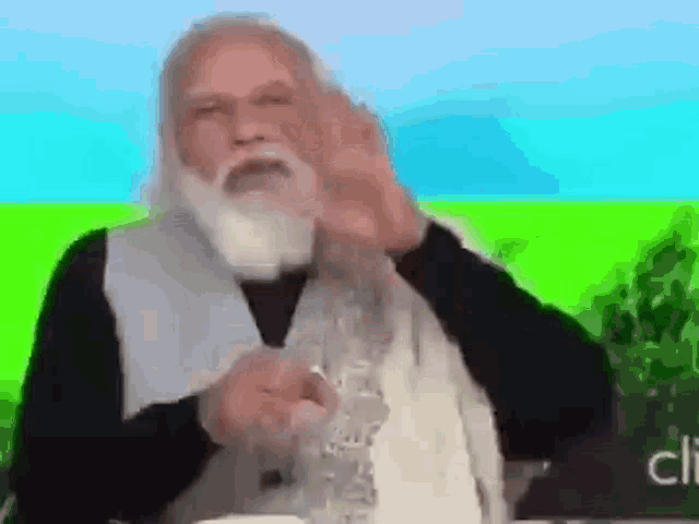 a man with a beard is giving a speech in front of a green field .