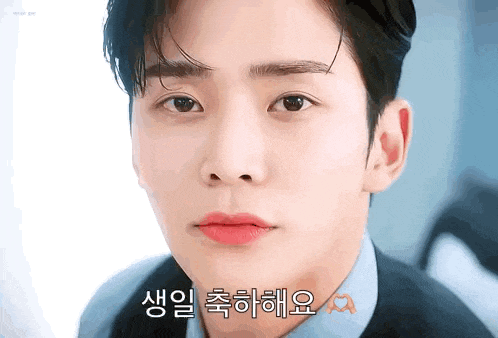 a close up of a man 's face with korean writing on his face .