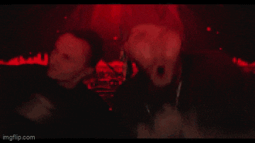 a man with a crown on his head is screaming in a red background .