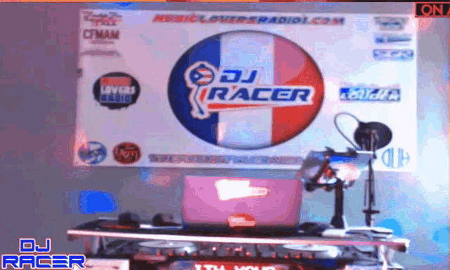 a dj racer sign hangs on a wall above a table