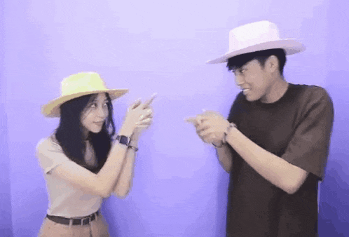 a man and a woman wearing hats are standing next to each other .
