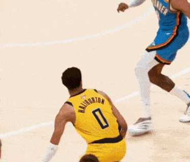 a basketball player with the number 0 on his back dribbles the ball