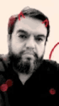a man with a beard and horns on his head is taking a selfie .