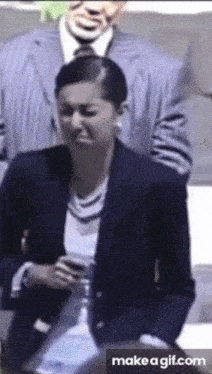 a woman in a suit is making a funny face