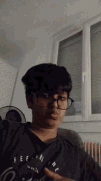 a person wearing glasses and a shirt that says " feel " on it