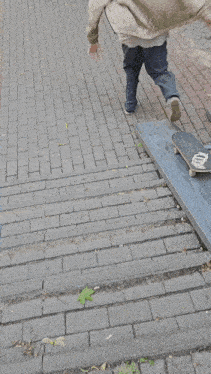 a man riding a skateboard on a brick sidewalk
