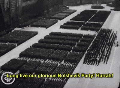 a black and white photo of a parade with the words long live our glorious bolshevik party hurrah