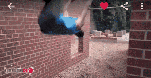 a man is doing a trick in front of a brick wall with the word bodybuilding on the bottom right