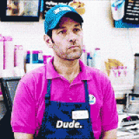 a man wearing a pink shirt and an apron that says dude on it