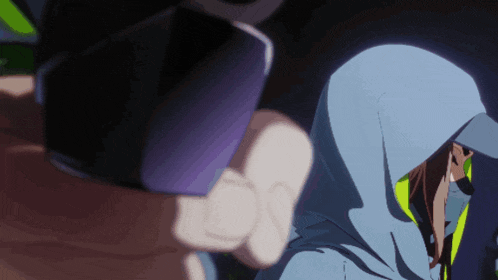 a person in a blue hoodie is holding a purple object in their hand