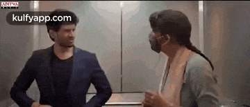 a man and a woman are standing next to each other in an elevator .