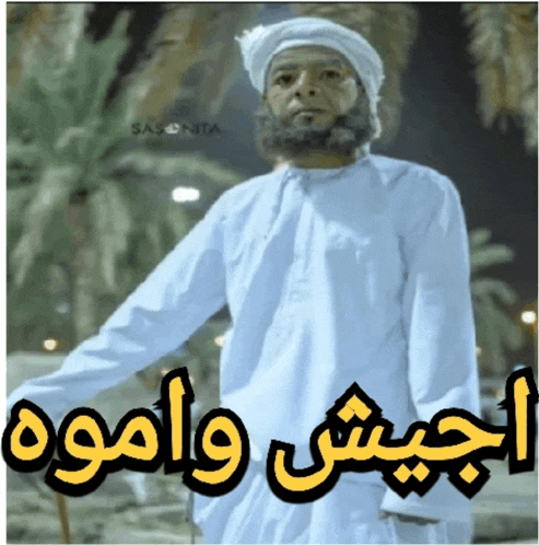a man with a beard is wearing a white shirt and a white turban with arabic writing on it